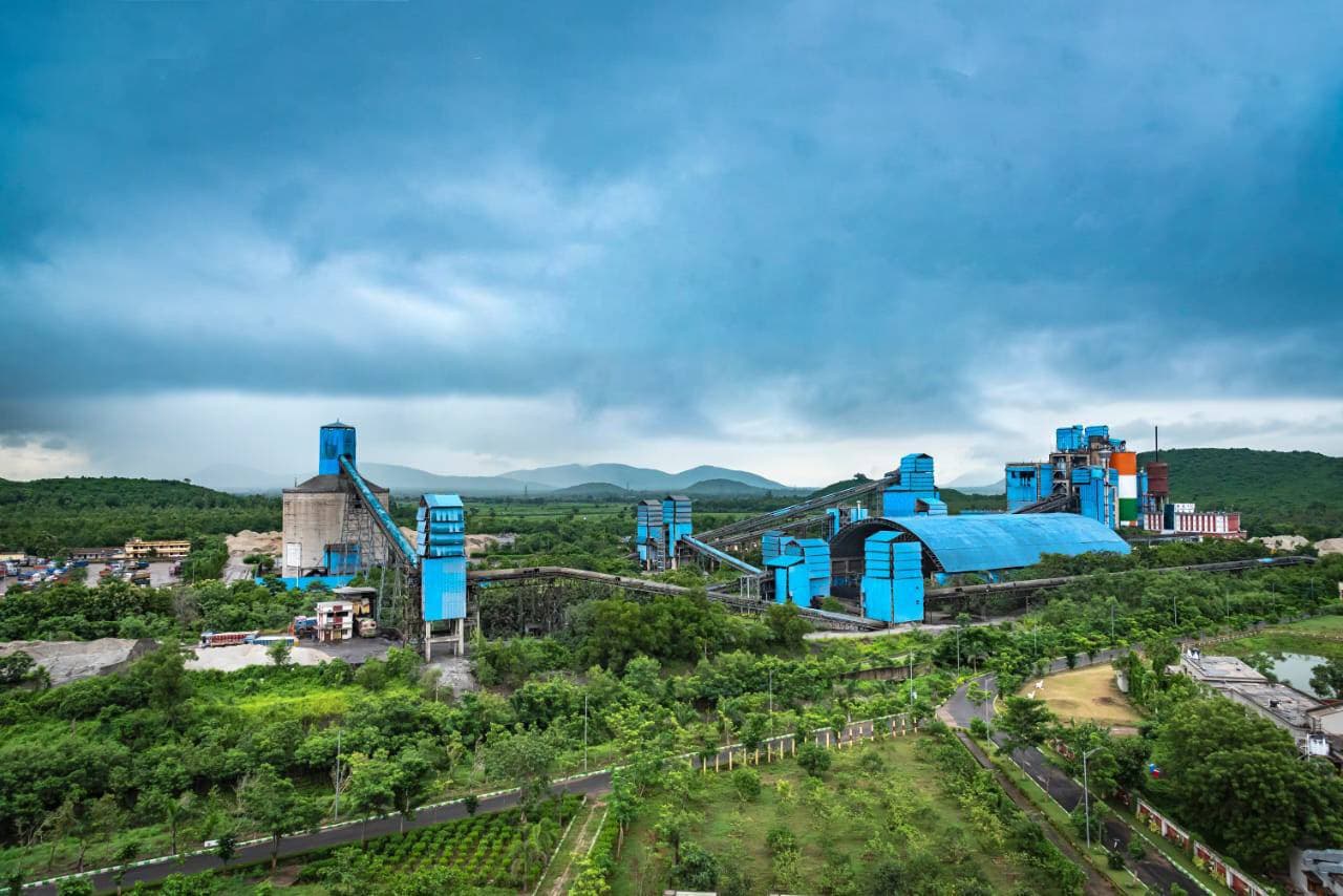 A Dalmia plant surrounded by trees and green landscape